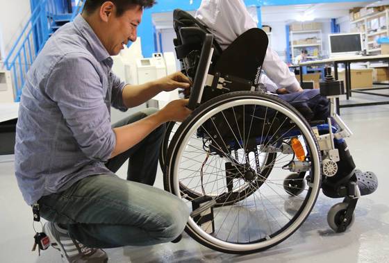 심재신 토도웍스 대표가 한 아이의 수동 휠체어에 토도드라이브를 장착하고 있다. [사진 토도웍스]