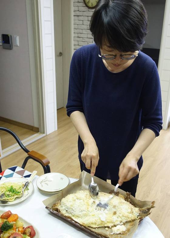 오븐에서 25분쯤 가열해 꺼낸 참돔소금구이에서 소금을 벗겨내는 김현정 셰프. 복잡할 것 같은 요리를 놀이하듯 힘도 안 들이고 해냈다. 소금을 계란 흰자로 반죽해 바르는 이유는 그래야 소금이 참돔 껍질에 붙지 않는다고 한다.