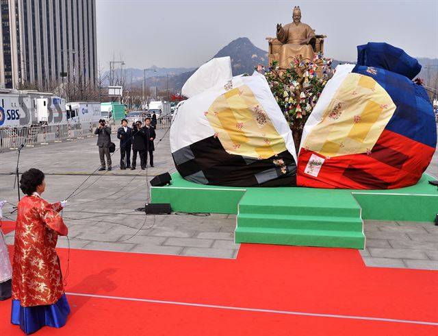 [박근혜의 3일] 서울 여의도 국회의사당에서 취임식을 마친 박 전 대통령이 청와대로 향하다 광화문광장에서 열린 '희망이 열리는 나무' 제막식에서 오방낭 주머니를 열고 있다. 사진공동취재단