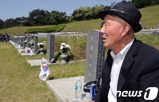 5·18광주민주화운동 37주년 기념식을 사흘 앞둔 14일 오전 광주 북구 운정동 국립5·18민주묘지, 문재학 열사의 부친 문건양씨(83)가 아들 묘지 앞에 앉아 있다. 2017.5.14/뉴스1 © News1 박윤식 기자