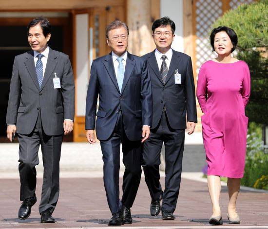 문재인 대통령이 15일 거처를 청와대로 옮긴 이후 처음으로 여민관 집무실에 출근하기 위해 부인 김정숙 여사(오른쪽 첫 번째)의 배웅을 받으며 주영훈 경호실장(왼쪽 첫 번째), 송인배 전 더불어민주당 일정총괄팀장(오른쪽 두 번째) 등과 함께 관저에서 나오고 있다. 청와대사진기자단