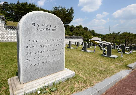 On May 17, a day before the 37th anniversary of the May 18 Democratic Uprising, the Taegeukgi and flowers are placed before a tombstone for the missing victims at the May 18th National Cemetery in Unjeong-dong, Buk-gu, Gwangju. The graves here were prepared for the citizens whose bodies were never found after they disappeared at the time of the May 18 uprising. Yi Jun-heon