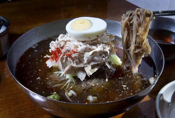 군산 뽀빠이냉면은 평양냉면에 대한 선입견을 과감히 깬다. 간장으로 간을 해 거무튀튀한 육수와 두툼히 얹어주는 닭고기, 돼지고기 고명이 이색적이다. [중앙포토]