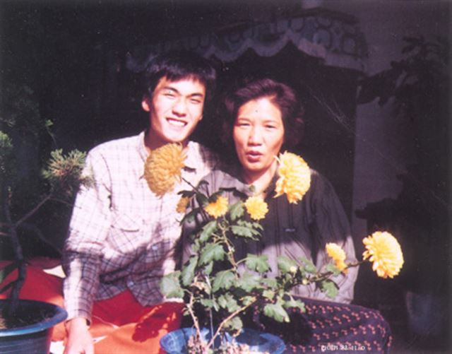 이한열(왼쪽) 열사와 어머니 배은심(오른쪽)씨가 1986년 가을 전남 광주 지산동 집에서 노란 국화 화분을 앞에 놓고 사진을 찍고 있다. 이한열기념사업회 제공.