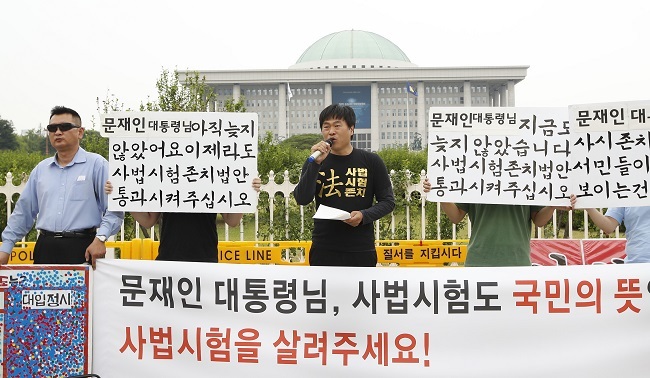 A student representative speaks at a press conference in front of the National Assembly in Seoul on Wednesday, calling for the government not to abolish the state-run bar exam. (Yonhap)