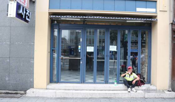 주인을 찾지 못하고 있는 점포앞에서 한 남성이 막걸리를 마시고 있다.