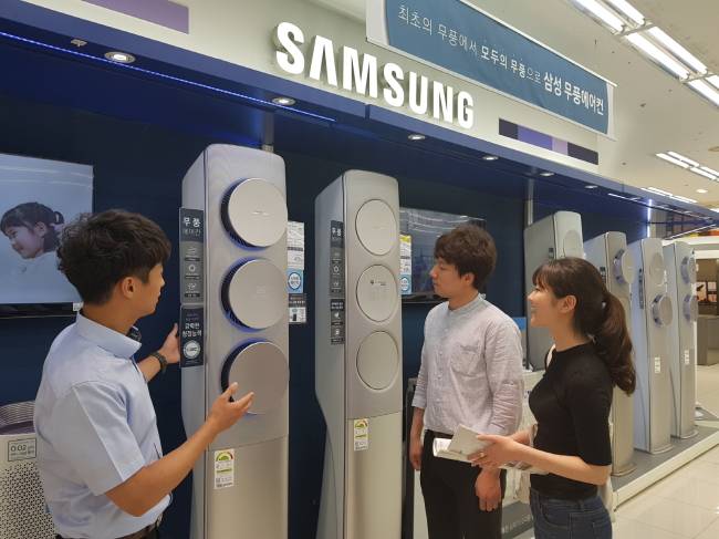 Consumers look at a floor-standing, wind-free air conditioner at a Samsung Electronics flagship store. (Samsung Electronics)