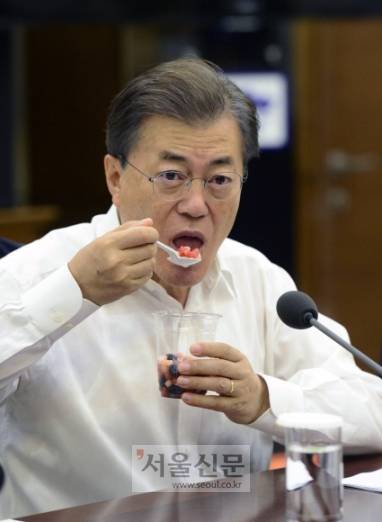 27일 청와대 여민관에서 열린 대통령 주재 수석 보좌관회의에서 문재인 대통령이  지난 충북지역 수해로 인해 피해를 입은 농가에서 구매한 과일 화채를 먹고 있다.  이 화채는 김정숙 여사의 제안으로 진평, 음성지역 농가에서 복숭아는 낙과, 블루베리와 수박은 침수과일을 구매해 만들었다. 안주영 기자 jya@seoul.co.kr