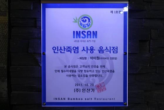 음식점 입구에 걸려있는 ‘인산죽염 사용 음식점’ 표지. 2011년 제1호점으로 받았다. 주인 부부는 음식점을 열기 전 인산죽염 대리점을 했다.