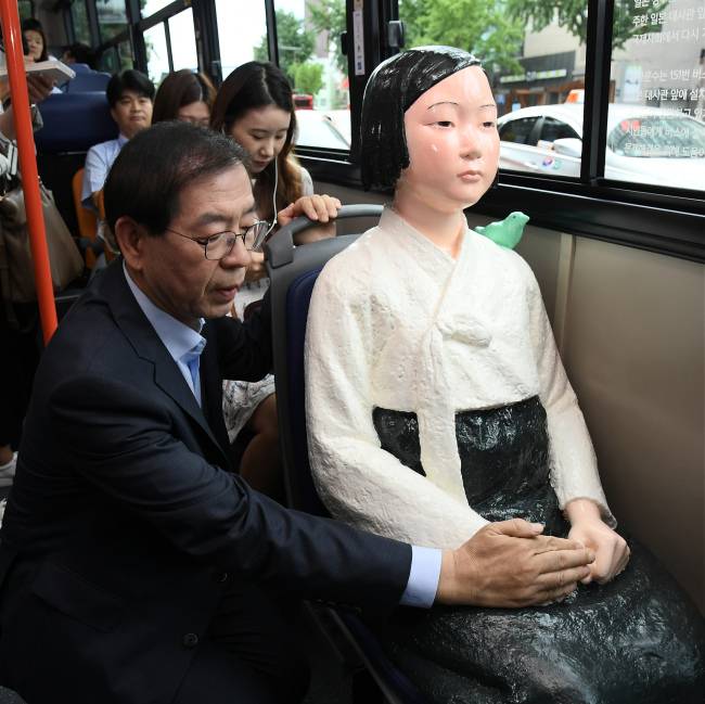박원순 시장이 14일 ‘151번’ 버스에서 소녀상을 어루만지며 살펴보고 있다. [사진제공=서울시]