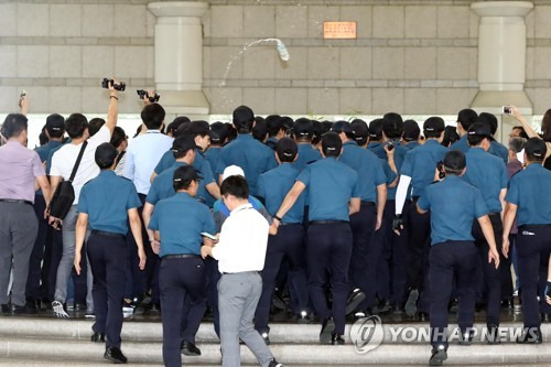 박영수 특별검사가 이달 7일 오후 서초구 서울중앙지방법원에서 열린 이재용 삼성전자 부회장의 결심 공판에 출석하기 위해 법원으로 들어서자 박근혜 전 대통령 지지자가 박 특검에게 생수병을 던지고 있다. [연합뉴스 자료사진]