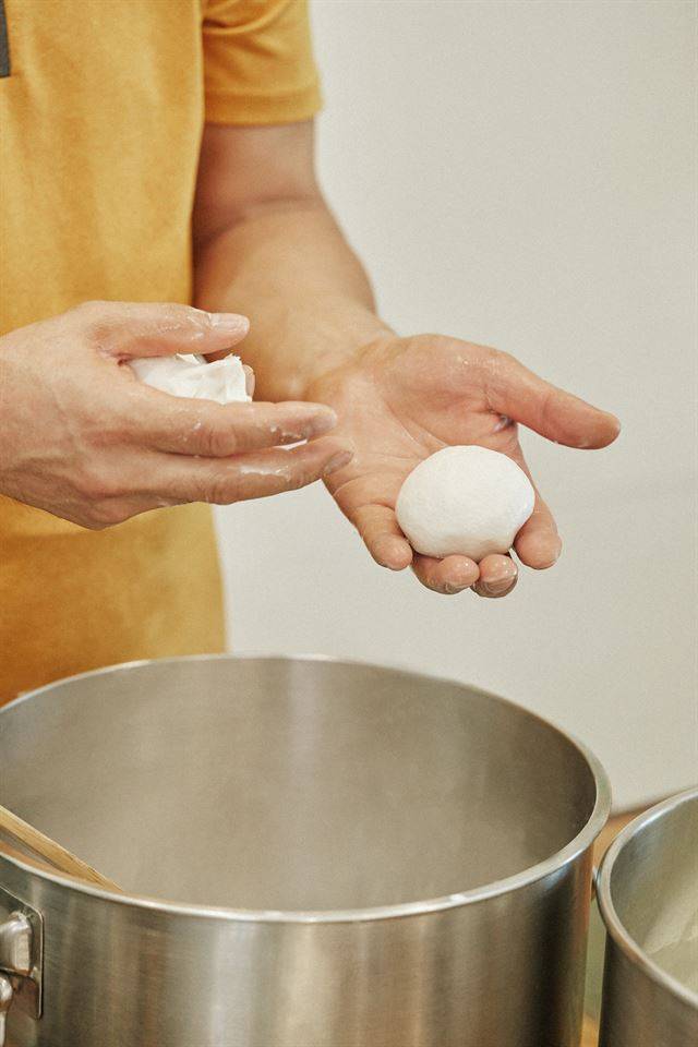 ⑤ 온도가 식으면 손으로 원하는 모양을 잡는다. 동그랗게 만들면 프레시 모차렐라가 되고, 엿가락처럼 늘이면 스트링 치즈가 된다. 완성된 치즈를 20% 소금물에 살짝 담가 염지하면 완성.