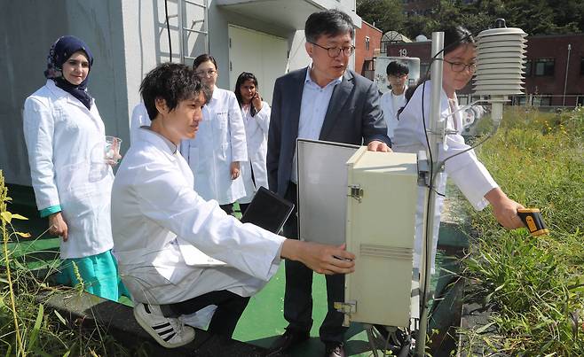 서울대 건설환경공학부의 한무영(가운데) 교수가 학생들과 지난 4일 서울대 공학관 옥상에 마련한 텃밭에서 저수량과 온도 등을 측정하고 있다. 김춘식 기자