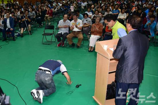 5일 오후 서울 강서구 탑산초등학교에서 열린 강서지역 특수학교 설립 교육감-주민토론회에서 장애 아이를 둔 지역주민이 특수학교설립을 반대하는 주민들을 향해 큰절을 하고 있다. (사진=윤창원 기자)