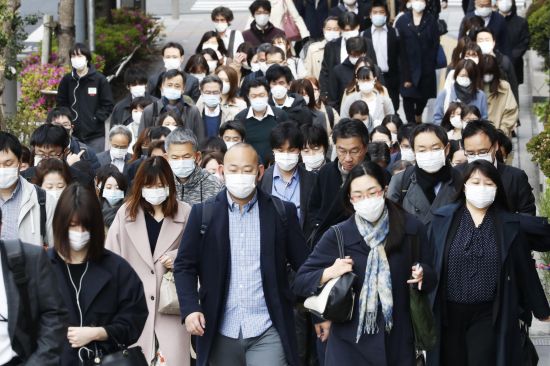일본 도쿄의 한 거리에서 마스크를 착용한 통근자들이 이동하고 있다. 연합뉴스