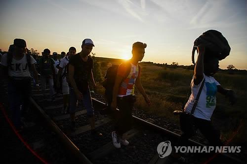 (헝가리 EPA=연합뉴스) 26일(현지시간) 세르비아와 접한 헝가리의 로스체에서 난민들이 철도를 따라 이동하고 있다. 수만명의 난민들은 유럽연합(EU) 국가로 입국하기 위해 그리스에서 세르비아와 마케도니아를 거쳐 헝가리로 향한다. eunsu@yna.co.kr (끝)