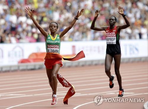 (베이징 AP=연합뉴스) 마레 디바바(왼쪽)가 케냐의 헬라 키프롭을 1초 차로 제치고 결승선을 통과하고 있다. 디바바는 30일 중국 베이징에서 열린 세계육상선수권대회 여자 마라톤에서 우승을 차지했다.