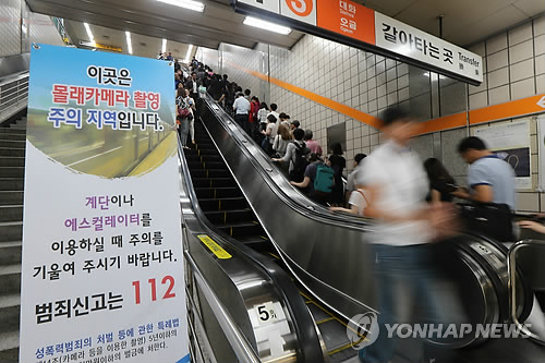 서울 지하철 에스컬레이터 앞에 '몰래카메라 촬영 주의지역'을 알리는 지하철 경찰대의 입간판이 서 있다 (연합뉴스 자료사진)