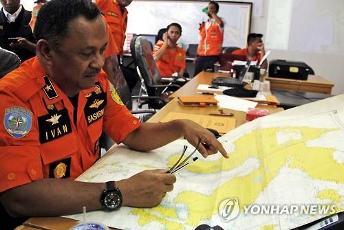 인도네시아 당국자가 실종된 에비아스타 항공 소속 여객기를 수색하기 위해 5일 구조센터에서 지도를 들여다보고 있다.(AP=연합뉴스)