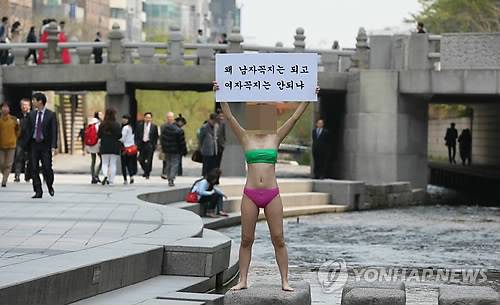 자신의 사회관계망서비스(SNS)를 통해 수위가 높은 동영상과 사진을 유포·판매해 논란을 빚은 일명 '아우디녀'에게 8일 징역 4개월에 집행유예 1년이 선고됐다. 사진은 지난 4월 '아우디녀' A씨가 청계천에서 1인 시위를 하고 있는 모습. (연합뉴스 자료사진)