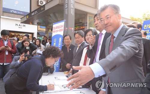 13일 오후 서울 여의도역에서 새정치민주연합 주최로 열린 '친일독재미화 국정교과서 반대 대국민 서명운동'에서 문재인 대표가 시민들에게 서명을 권유하고 있다.