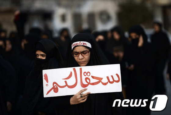 바레인 여성이 마나마 서부 지드하프스 지역에서 님르 사형에 반대하는 시위에 참석하고 있다. © AFP=뉴스1