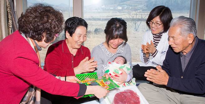 전남 해남군 보건소 관계자들이 지난 6일 해남군 화산면에 사는 산모 김혜정(32)씨를 찾아가 산후 조리식품과 신생아 내복을 선물하고 있다. [해남=프리랜서 오종찬]