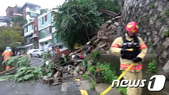 집중호우로 인해 서울 종로구 부암동 북한산 자락 한 주택 외벽축대가 무너져 출동한 종로소방서 대원이 사고 수습을 하고 있다(종로소방서 제공). © News1