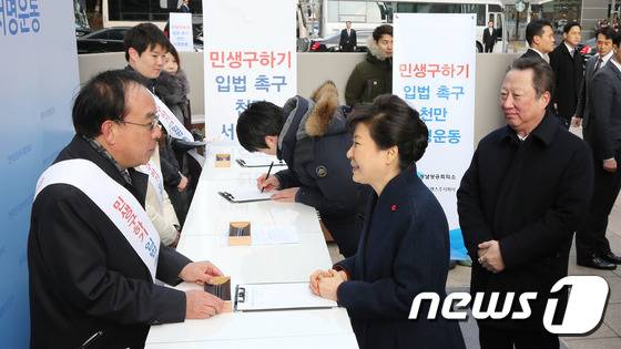 박근혜 대통령이 18일 경기도 성남 판교 네오트랜스빌딩 앞 광장을 방문해 '민생구하기 입법촉구 천만서명운동'부스에서 경제활성화법 입법을 촉구하는 서명을 하고 있다. (대한상의 제공) 2016.1.18/뉴스1