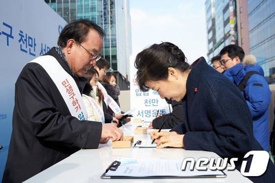 박근혜 대통령이 18일 경기도 판교테크노밸리에서 열린 창조경제와 문화융성 신년 업무보고 후 외부에 마련된 부스를 찾아 민생구하기 입법촉구 천만인 서명운동에 동참해 서명을 하고 있다. (청와대 제공) 2016.1.18/뉴스1 © News1 이광호 기자