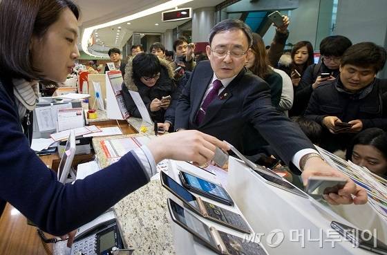 최성준 방송통신위원장이 지난 13일 오후 서울 중구 서울중앙우체국 알뜰폰 판매현장을 방문해 알뜰폰을 살펴보고 있다. 2016.1.13/뉴스1