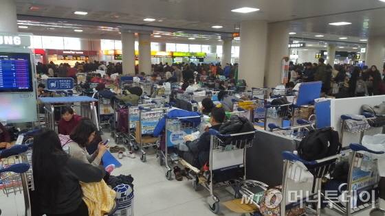 32년만의 폭설로 제주공항 운항중단이 삼일째 이어진 25일 오전 발이 묶인 관광객들이 제주공항 대합실에 앉아 운항재개를 기다리고 있다./사진=조성훈 기자