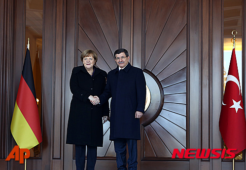 German Chancellor Angela Merkel, left, and Turkish Prime Minister Ahmet Davutoglu shake hands during a welcoming ceremony in Ankara, Turkey, Monday, Feb. 8, 2016. Merkel is meeting Davutoglu and other Turkish officials for talks on reducing the influx of migrants to Europe. Turkey, a key country on the migrant route to Europe, is central to Merkel's diplomatic efforts to reduce the flow. (AP Photo/Burhan Ozbilici)
