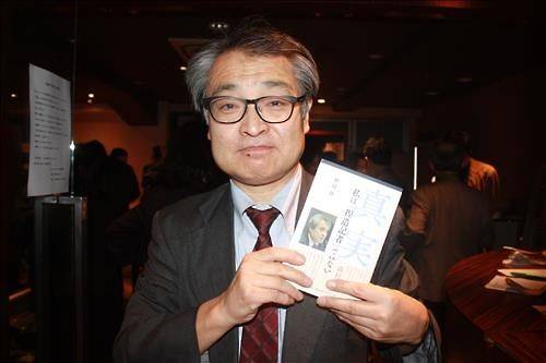 28일 열린 출판기념회에서 자신의 저서를 든 채 포즈를 취한 우에무라 씨.