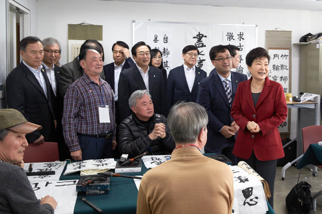 President Park Geun-hye talks with elderly citizens at a senior welfare center during her pre-election visit to Busan on Wednesday. Cheong Wa Dae