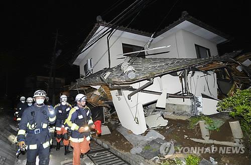 소방대원들이 구마모토현 마시키마치(益城町)에서 지진으로 무너진 가옥의 피해 상황을 살펴보는 모습.(AP=연합뉴스)