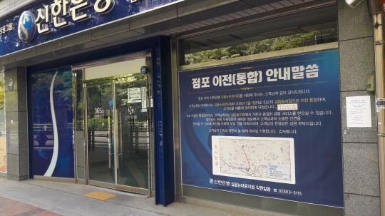 서울 성북구의 한 시중은행 입구에 붙여진 지점 통합 안내문 ⓒ데일리안