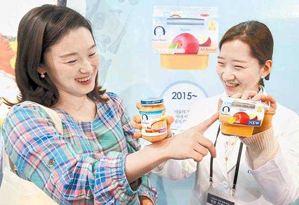 출산을 앞둔 주부가 거버 영·유아식 컨설턴트가 소개하는 단계별 영양 이유식 제품을 살펴보고 있다.