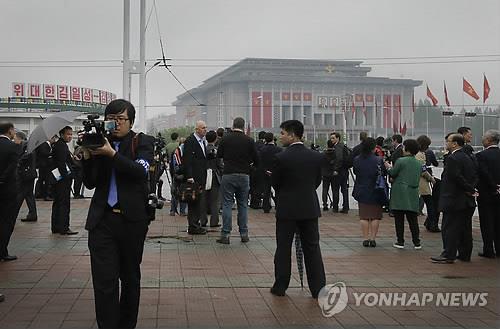 평양 AP=연합뉴스) 36년만에 열리는 북한 제7차 노동당 대회 개막일인 6일(현지시간) 외신기자들이 대회장인 평양 4·25문화회관 부근에서 사진을 찍거나 관련 기사를 보도하고 있다