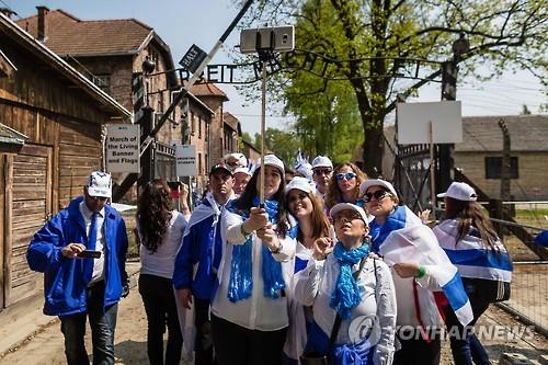 '노동이 자유롭게 하리라' 라는 문구가 있는 폴란드 아우슈비츠 수용소 앞, 행사 참가자들 모습 (AFP=연합뉴스)