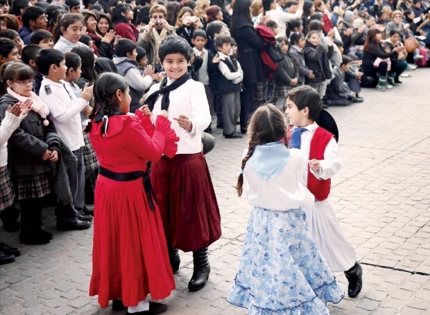 전통옷을 입은 어린이들이 춤을 추고 있다.