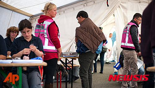 【 외르브케=AP/뉴시스】 독일 북부 외르브케에 마련된 난민 센터에서 12일(현지시간) 자원봉사자들과 의료진이 난민들의 건강상태를 체크하고 있다. 2015.09.13