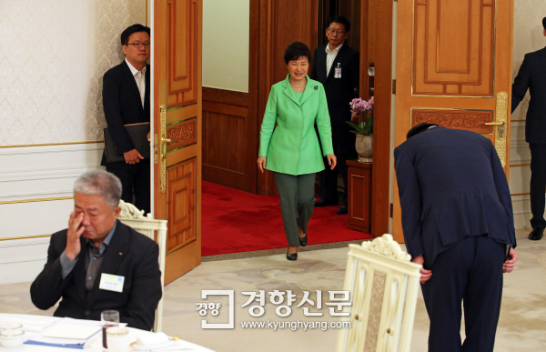 지난해 9월 22일 박근혜 대통령이 청와대에서 열린 노사정 대표들과의 오찬장에 들어서자 이기권 고용노동부 장관(오른쪽)이 일어서서 허리를 깊숙이 숙여 90도로 인사하고 있다. 김동만 한국노총 위원장(왼쪽)은 뒤돌아보지 않은 채 앉아 있다. / 청와대사진기자단