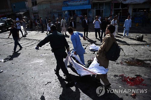 23일 아프가니스탄 수도 카불에서 주민들이 폭탄테러 희생자를 옮기고 있다.(AFP=연합뉴스)
