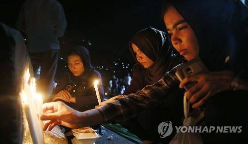 23일 아프가니스탄 수도 카불에서 여성들이 80명이 사망한 IS의 자폭테러 희생자들을 추모하며 촛불을 밝히고 있다.(EPA=연합뉴스)