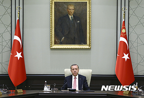 【앙카라=AP/뉴시스】레제프 타이이프 에르도안 터키 대통령이 지난 25일 앙카라에서 터키 건국의 아버지 무스타파 케말 아타튀르크의 초상화가 걸린 아래에 앉아 국무회의를 주재하고 있다. 지난 25일 터키 언론인 42명에 대해 체포영장을 발부했던 터키 당국은 27일 지난 15일의 쿠데타 배후세력이라는 비난을 받고 있는 재미 이슬람 학자 펫훌라흐 귈렌과 연관돼 있는 신문 '자만'의 전 경영진과 고위 언론인 47명에 대해 추가로 체포영장을 발부했다. 2016.7.27