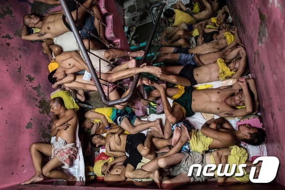 수감자 포화 상태인 필리핀 마닐라 교도소의 수감자들이 계단 위에서 잠을 청하고 있다. 이 교도소는 수용 인원이 최대 800명이지만 최근 로드리고 두테르테 정부가 마약, 폭력 범죄자들을 대거 체포하면서 4000여명이 지내고 있다. © AFP=뉴스1