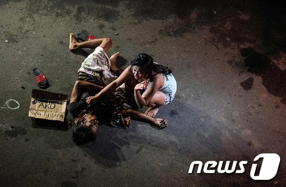 제닐린 올라이레스가   마닐라  거리에서  마약사범으로 몰려 총에 맞아 숨진 연인 미카엘 시아론을 보며 비통해하고 있다.  © AFP=뉴스1