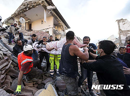 【아마트리체(이탈리아)=AP/뉴시스】24일 이탈리아 중부를 규모 6의 강진이 덮쳐 최소 120명이 사망한 가운데 구조된 한 여성이 들것에 실려 이송되고 있다. 2016.8.25