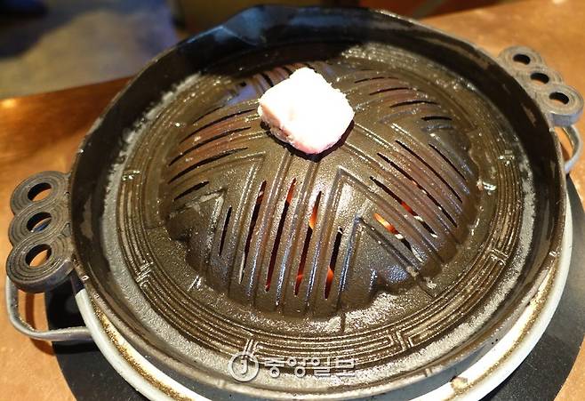칭기즈칸 요리용 투구 모양의 주물 불판 홈으로는 기름이 흘러내려가 채소를 익혀주고 틈으로는 숯불이 올라와 고기에 숯향과 불맛을 더해준다.